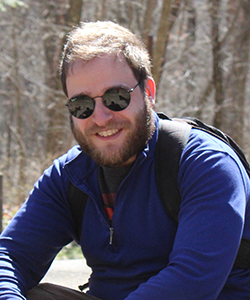 graduate student wearing sunglasses smiling