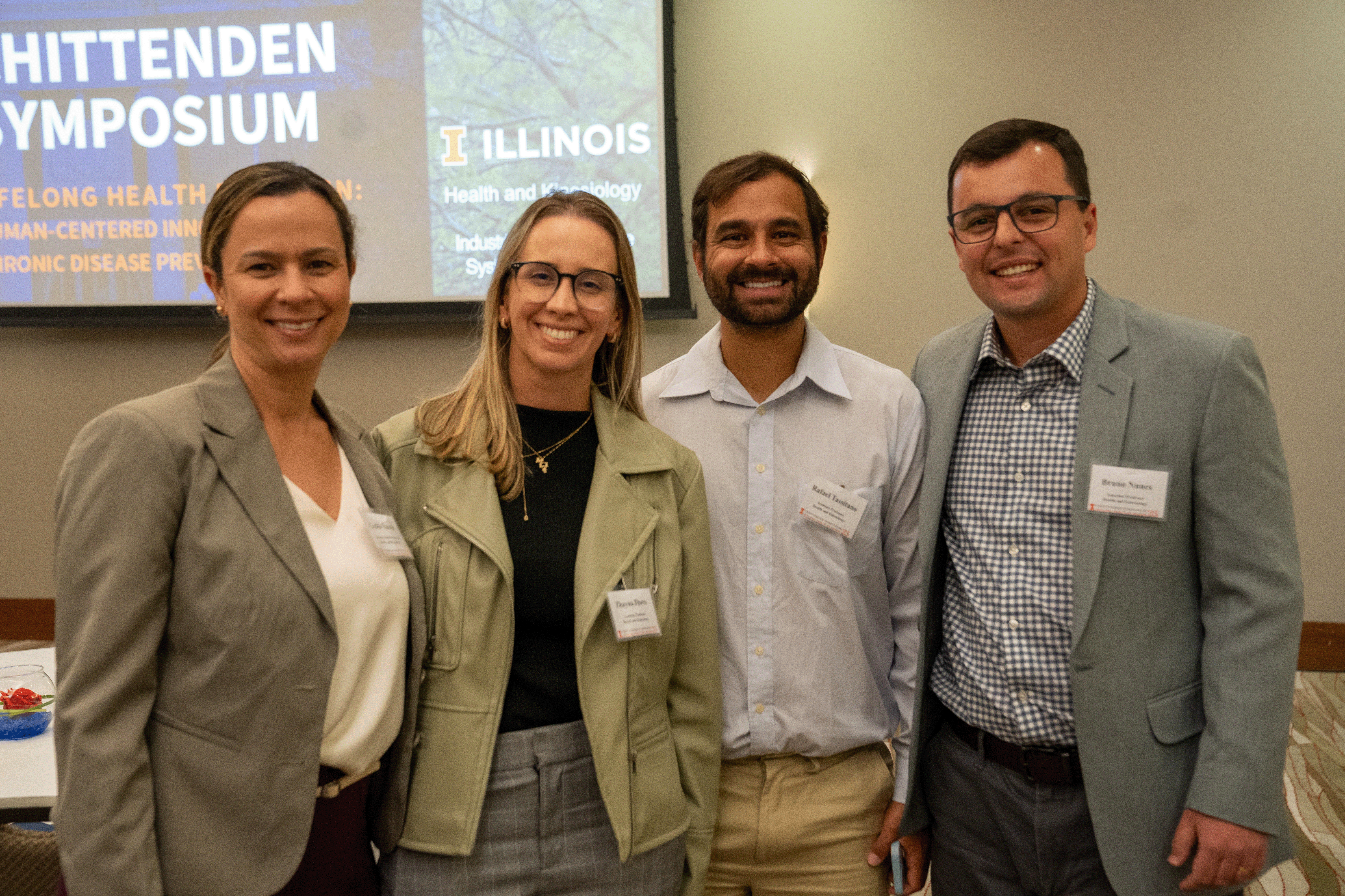 four people posing and smiling