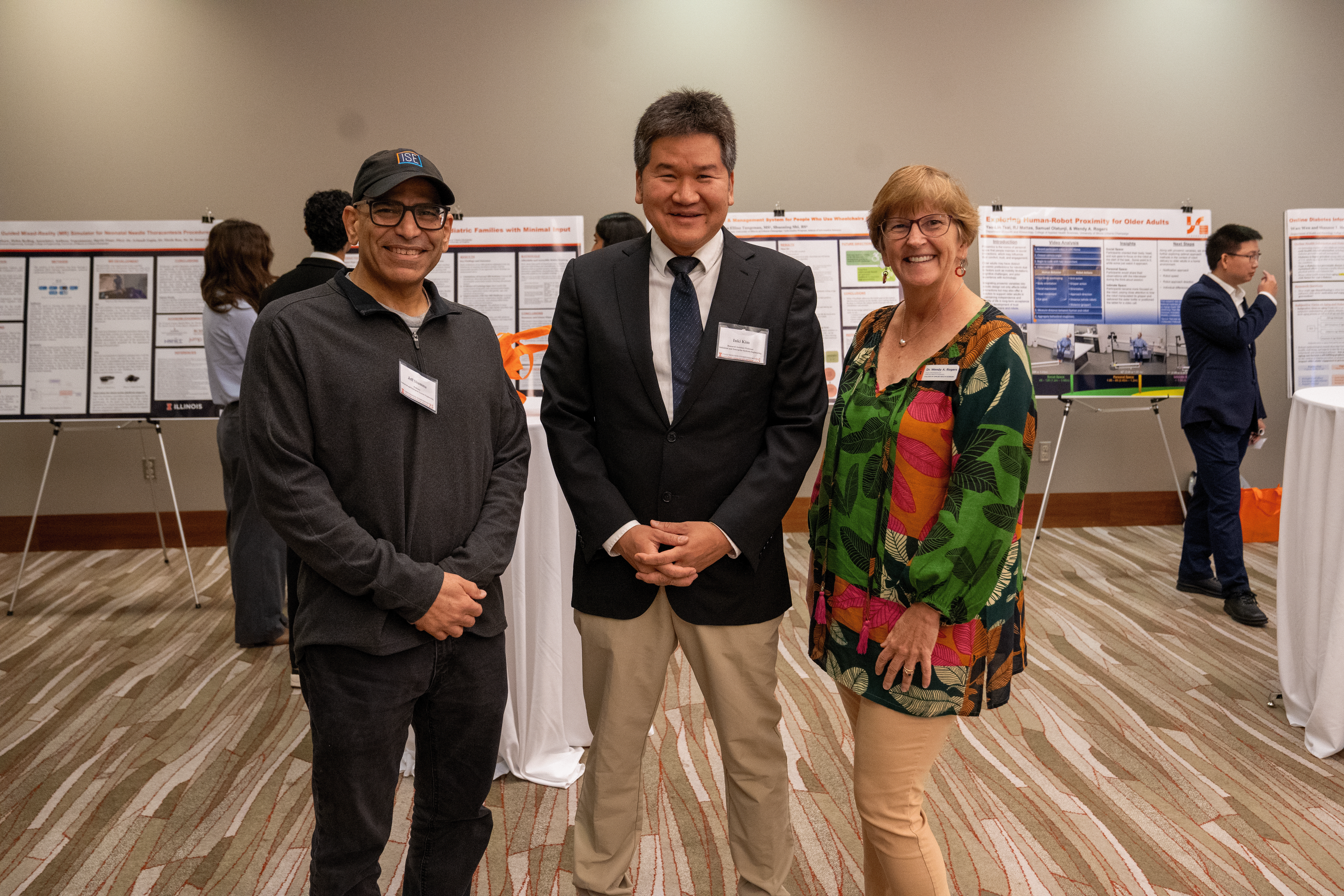 three grainger engineering faculty smiling at an event