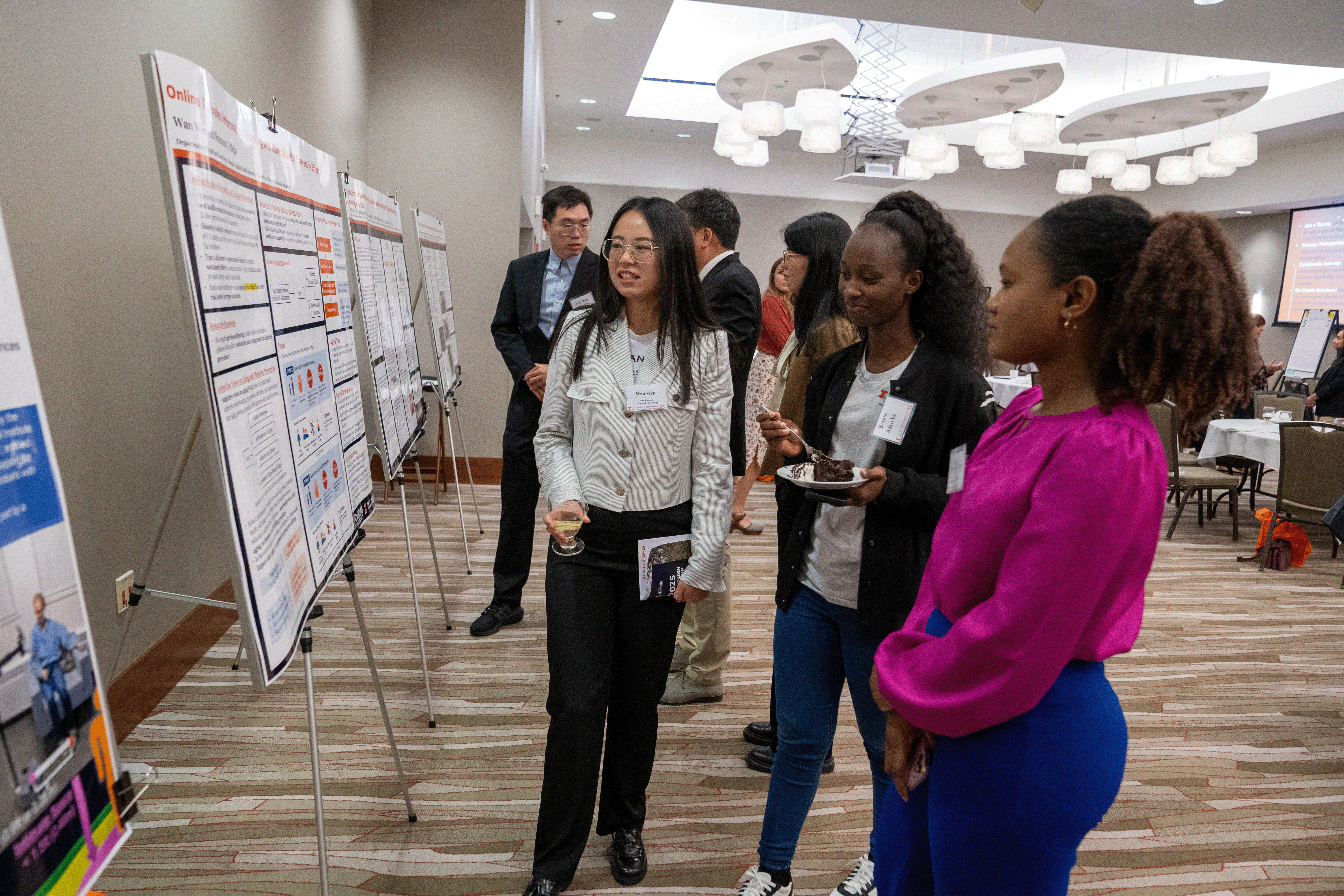 three students standing in front of a poster presentation