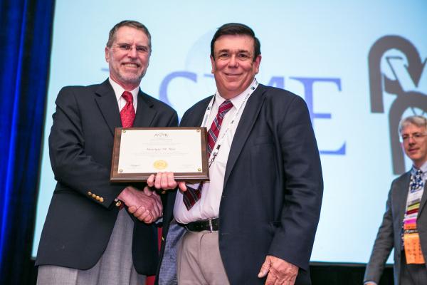 Professor Victor Giuriutiu from the University of South Carolina presenting the ASME award to Professor Reis