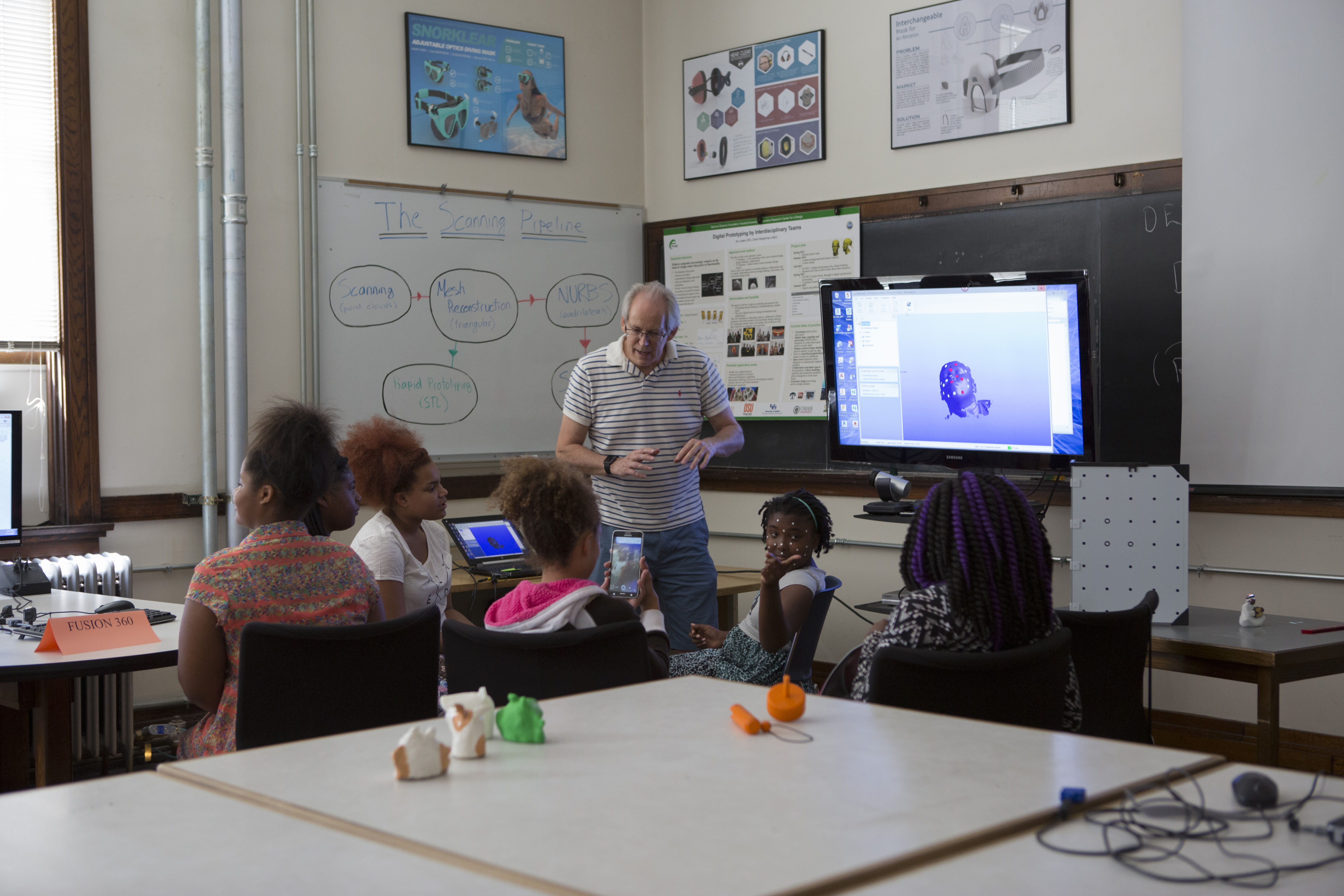 Director of Engineering Graphics and Product Design Lab Manager Jim Leake shows the students the wonders of 3D design and rendering.