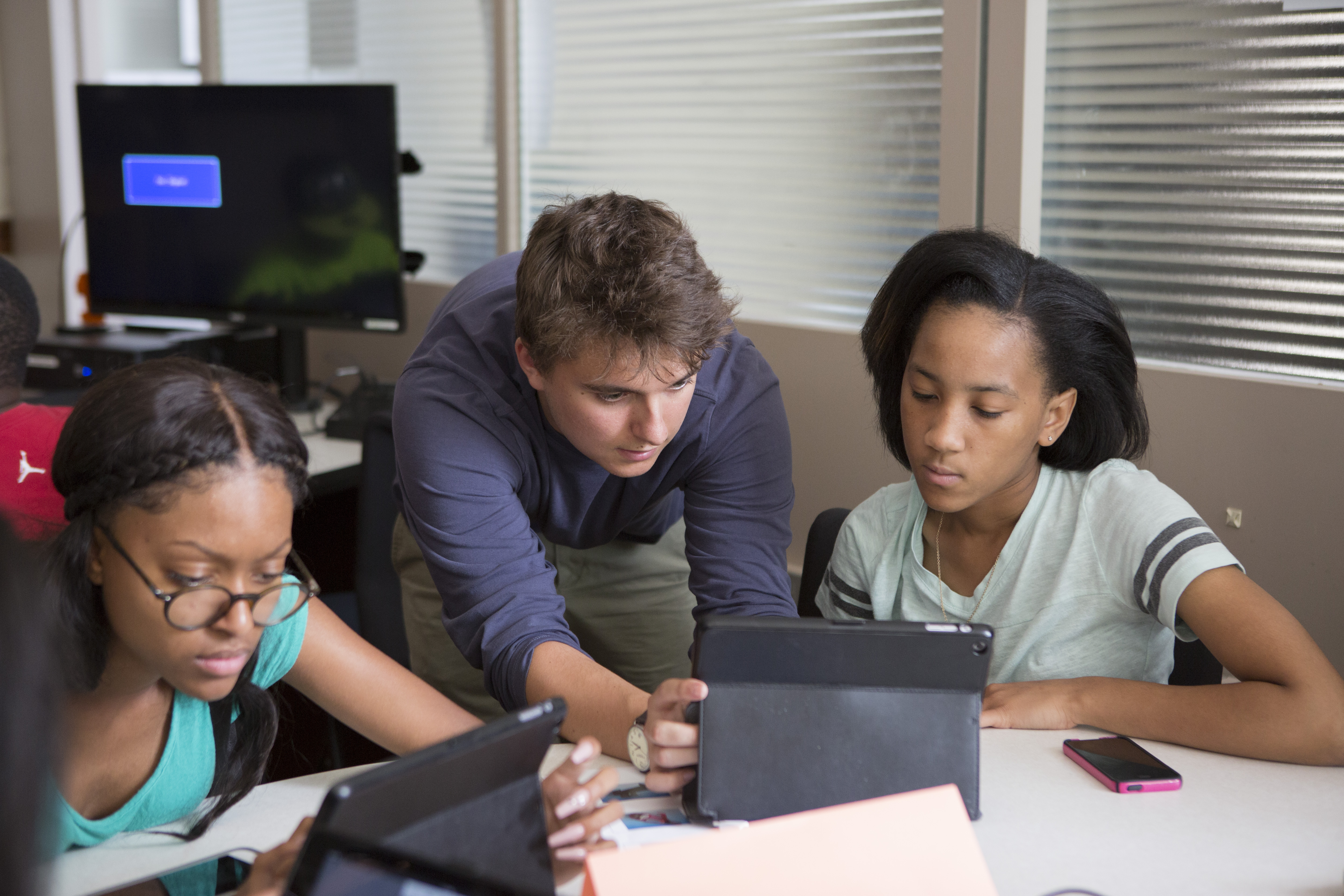 Product Design Lab Assistant and ISE undergraduate student Joey Lund (center) works with Daesha Winston and Alexis Stallworth, 9th grade.