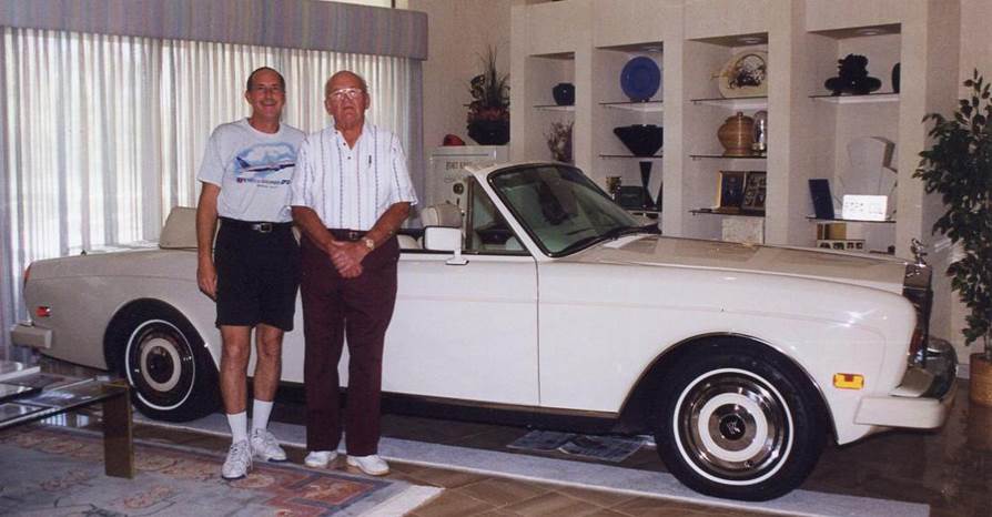 Holecek and Dobrovolny pose together in front of a Rolls Royce in Holecek's living room.