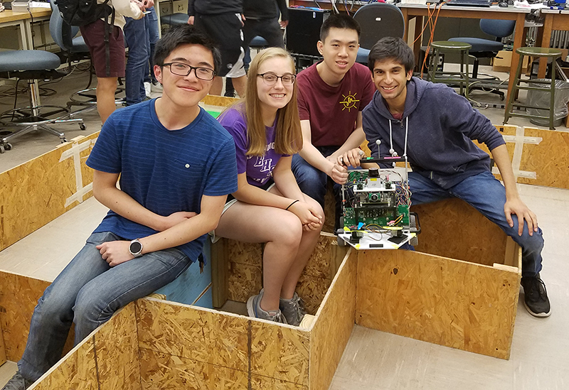 RuthAnn and her robotic mechatronics project. The Mechtronics (SE423) group worked on creating a wayfinding, weed-exterminating robotic car.  During that project, they worked with C programming, LabVIEW, and sensor data. Pictured are Keith Ng, RuthAnn Haefli, Hunter Ha Huynh, and Arjun Goradia.